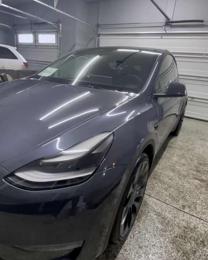 A grey Tesla inside the studio on the epoxy floor.