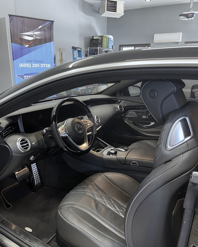 The interior of a Mercedes S-Class coupe, quilted leather and brushed pedals.