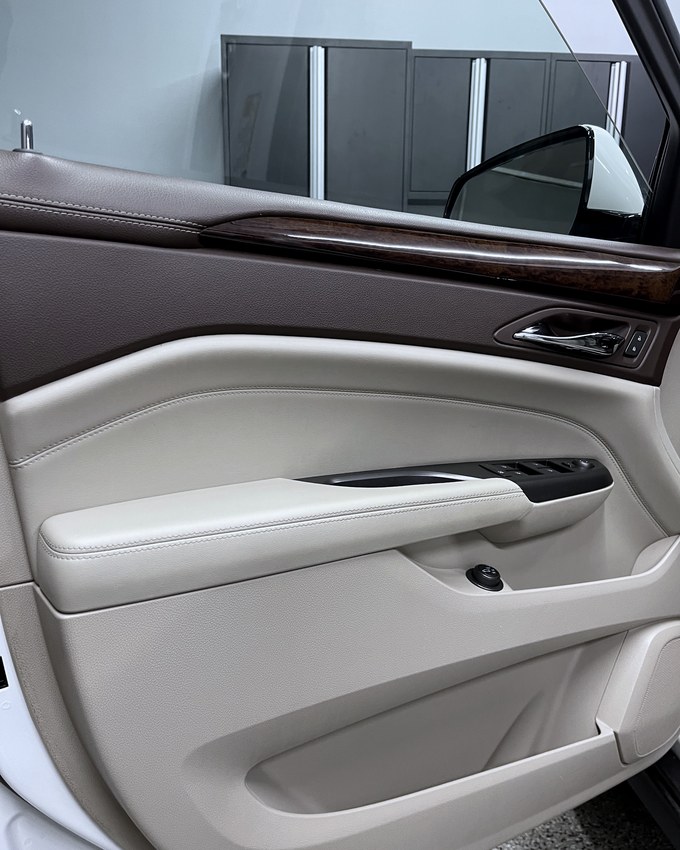 A cream leather door card and wood trim, cleaned and conditioned.